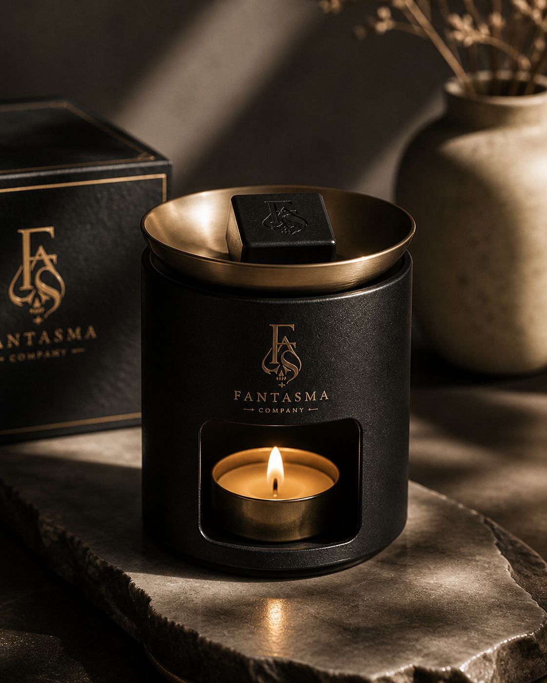 Fantasma black ceramic wax warmer with brass bowl and candle flame.